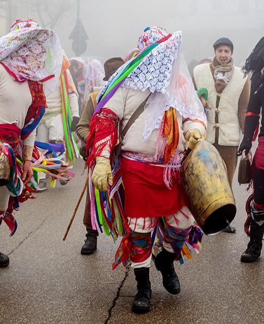 Maschere di Tricarico in corteo, con nastri colorati e campanaccio, nella nebbia del mattino